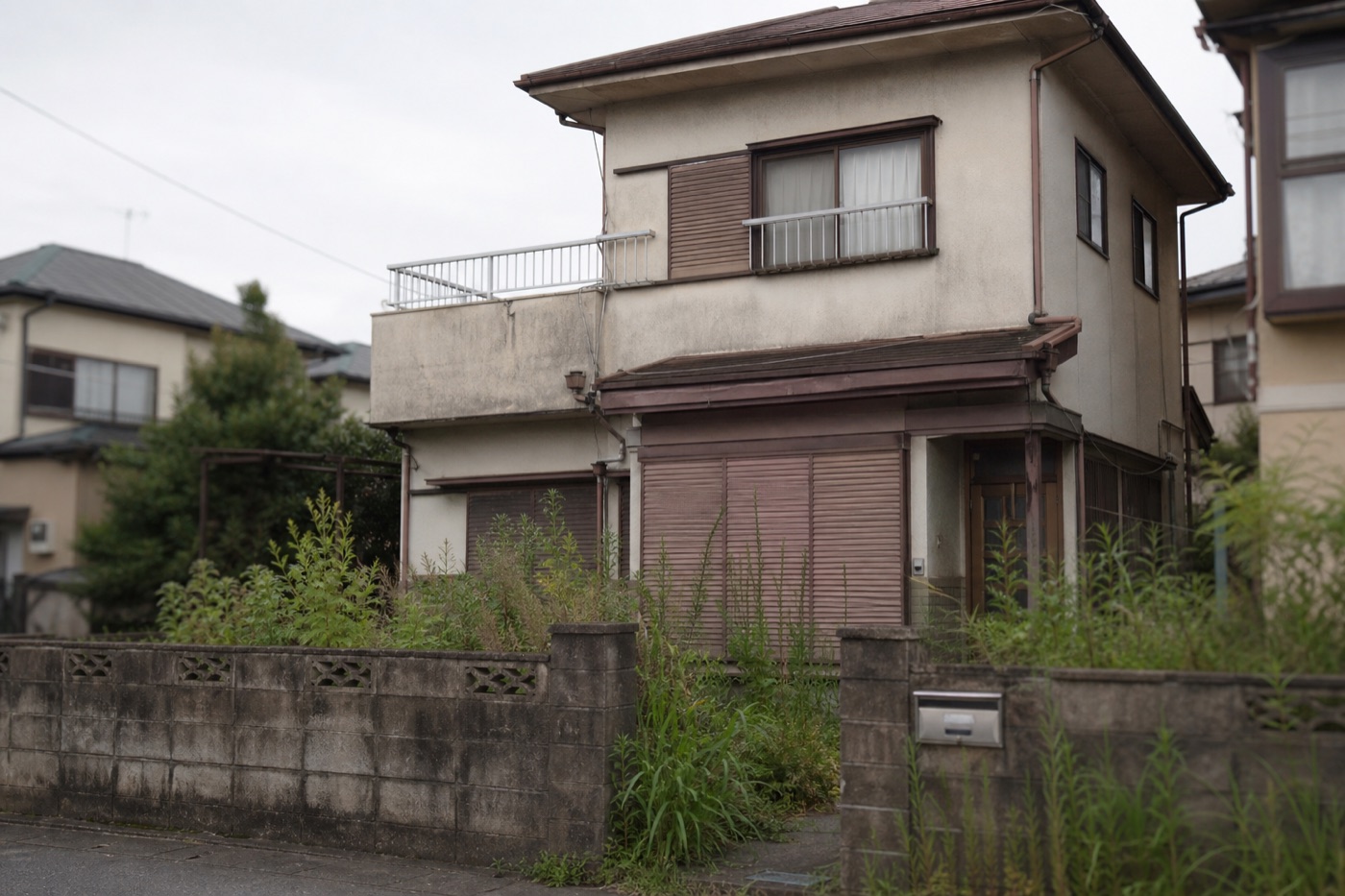 雑草が伸び、長く放置された空き家
